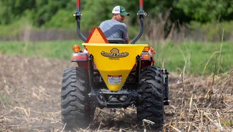 New Land Pride FSP Series Spreader attached to a tractor seeding a plot of land.