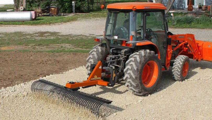 Land Pride LR16 Series Landscape Rake attached to the back of a Kubota tractor working a field.