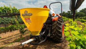 New Land Pride PFS Series Spreader attached to Kubota Tractor on a farm.