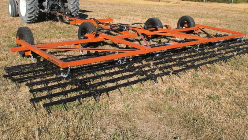 Land Pride STH20 Series Spike Tooth Harrows mounted to a tractor in a grassy field.