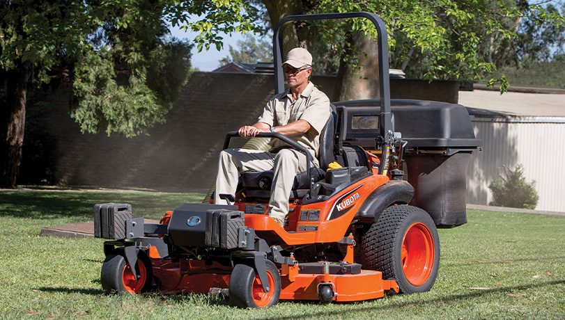 Person riding a ZD1211 mower in a residential area.