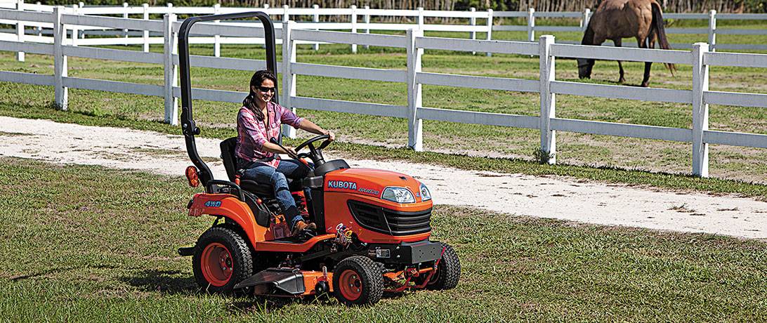 Woman driving Kubota tractor in field at Steen Enterprises, Charleston South Carolina dealer.