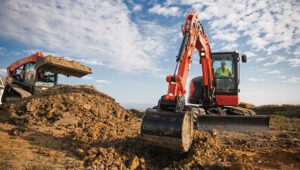 New Kubota KX057-5 Excavator on a heavy duty construction site clearing land and soil.