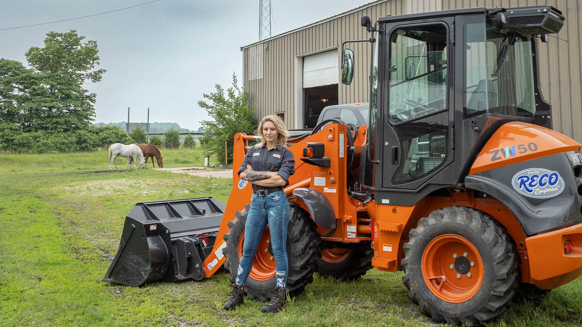 Melissa Petersmann, a.k.a. Diesel Queen, posting in front of a Hitachi Mini Loader